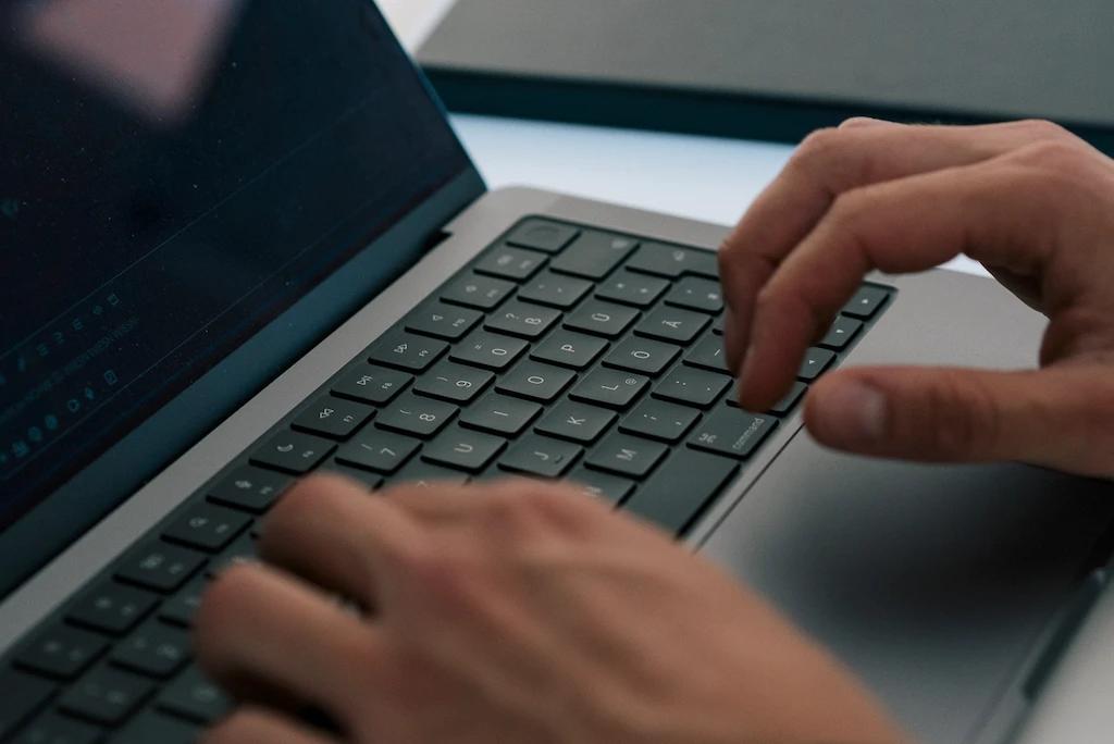 Hände tippen auf einer Notebook-Tastatur